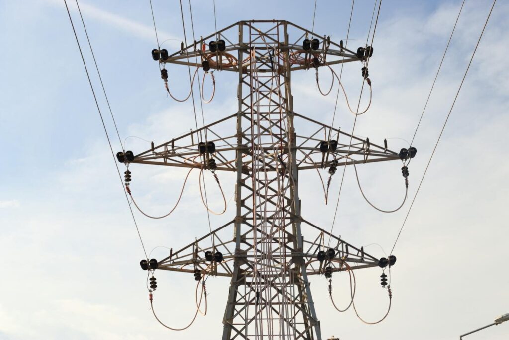 Steel transmission tower with power lines extending across the sky, showcasing modern infrastructure.